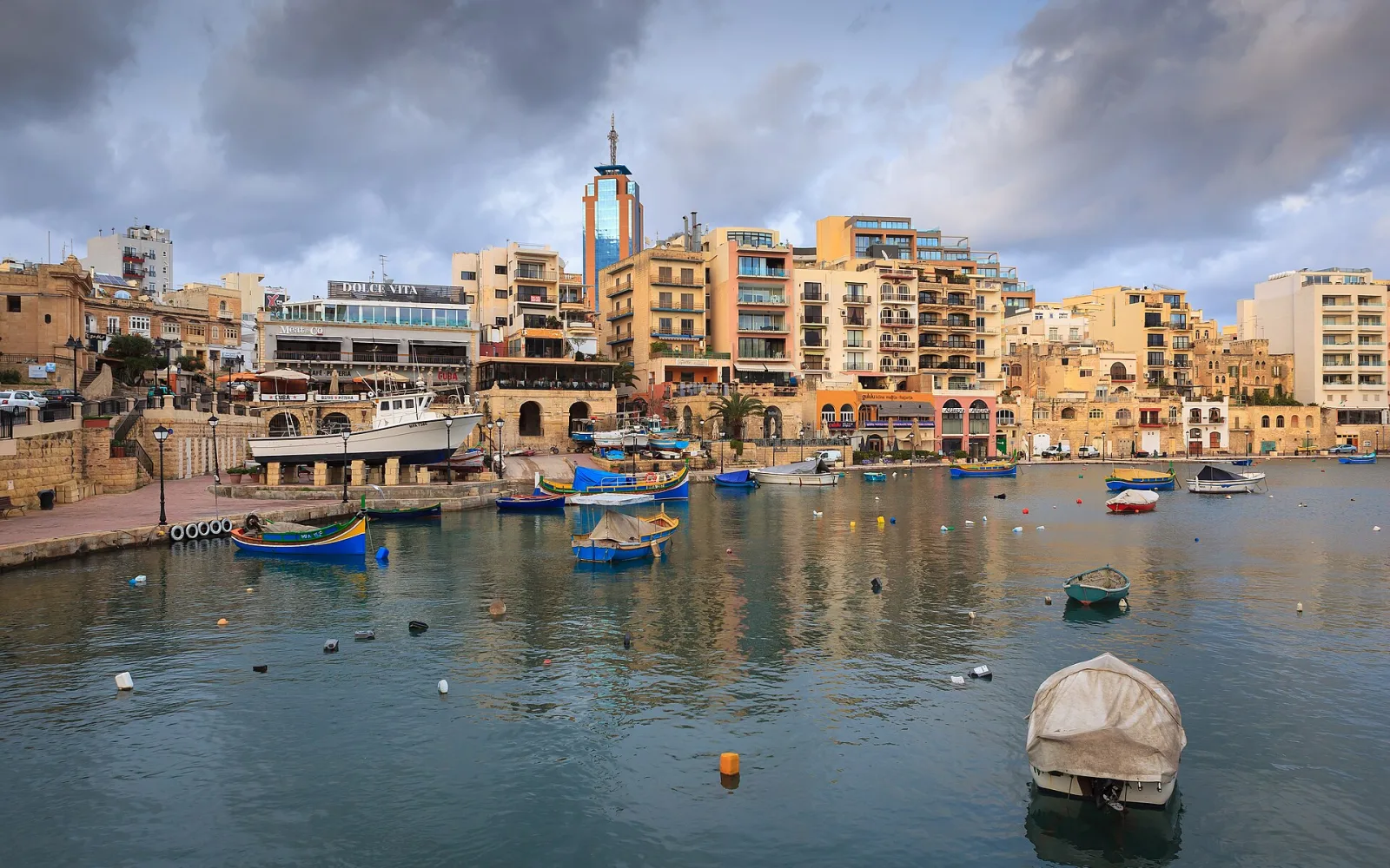 Traditional boats and waterfront buildings at Spinola Bay