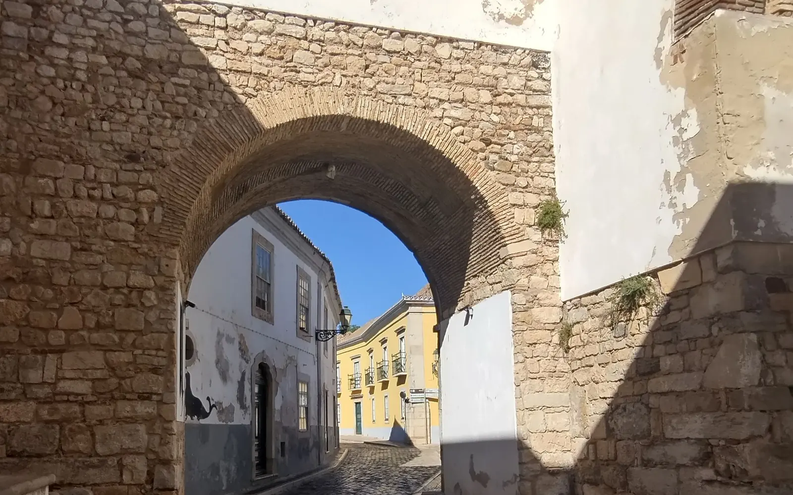 Stone arch and cobbled lane in Faro’s walled old town